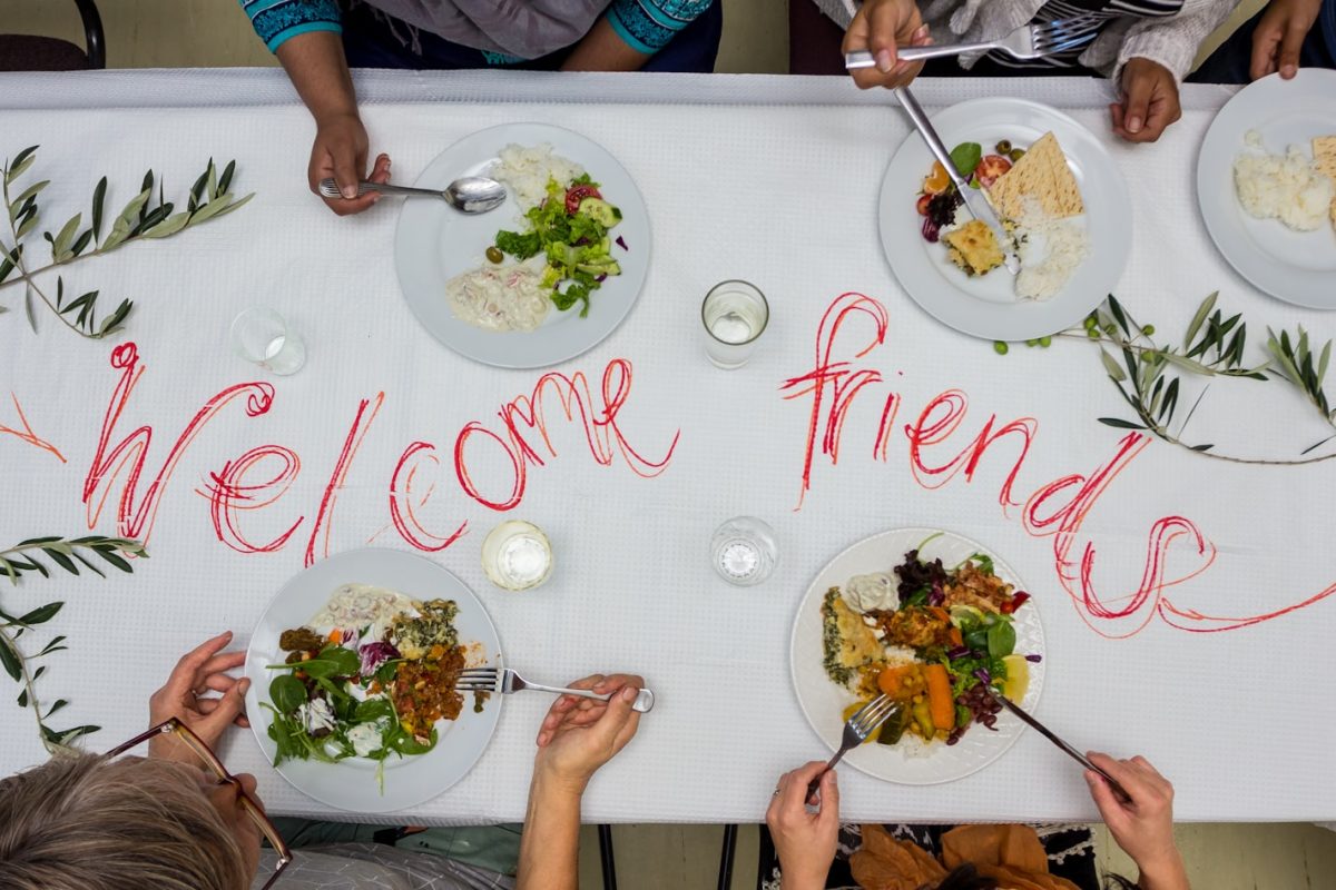 A group of people sitting around a table with plates of food